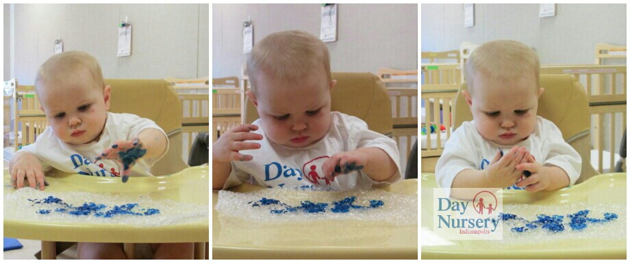 infant in high chair painting on bubble wrap