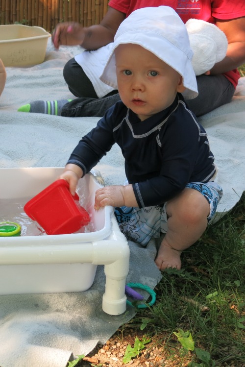 Infant playing in water outside