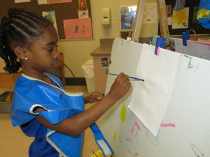 Day Nursery student painting on an easel